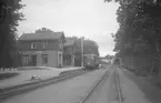 Strängnäs stationshus med motorvagn vid plattform.