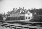 Ängelsberg station.
Första stationshuset togs i bruk 1876. Nytt stationshus byggdes 1900. Samma år byggdes bangården ut till sju spår .På smalspårstiden fanns inget egentligt stationhus, utan ett 1850 uppfört hamnkontor tjänstgjorde även som stationshus fram till breddningen 1875/76. Kombinerad station/poststation sedan 1865. Nytt stationshus uppfört av SWB 1875/76. Nya spår på bangården 1884 och 1894. Skyddsrum 1941 .Biljettförsäljningen upphör och stationen blir obemannad 1995/96