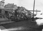 Statens Järnvägar, SJ B. Loket är utrustat med Marcottys rökförbränningsapparat vilket syns på plåtringen runt skorstenen.
Tåg 22 vid avgång från Stockholm Central station våren 1921.