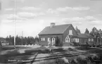 Station anlagd 1935. Envånings stationshus i trä, sammanbyggt i vinkel med godsmagasinet.