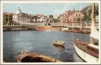 Järnvägsstationen och kyrkan i Strömstad fotograferat från båt eller brygga.