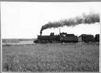 Lastat timmertåg på linjen mellan Östby och Ockelbo i närheten av Östby station. Tåget är draget av Malletlok, Dala - Ockelbo - Norrsundets Järnväg, DONJ lok 12.