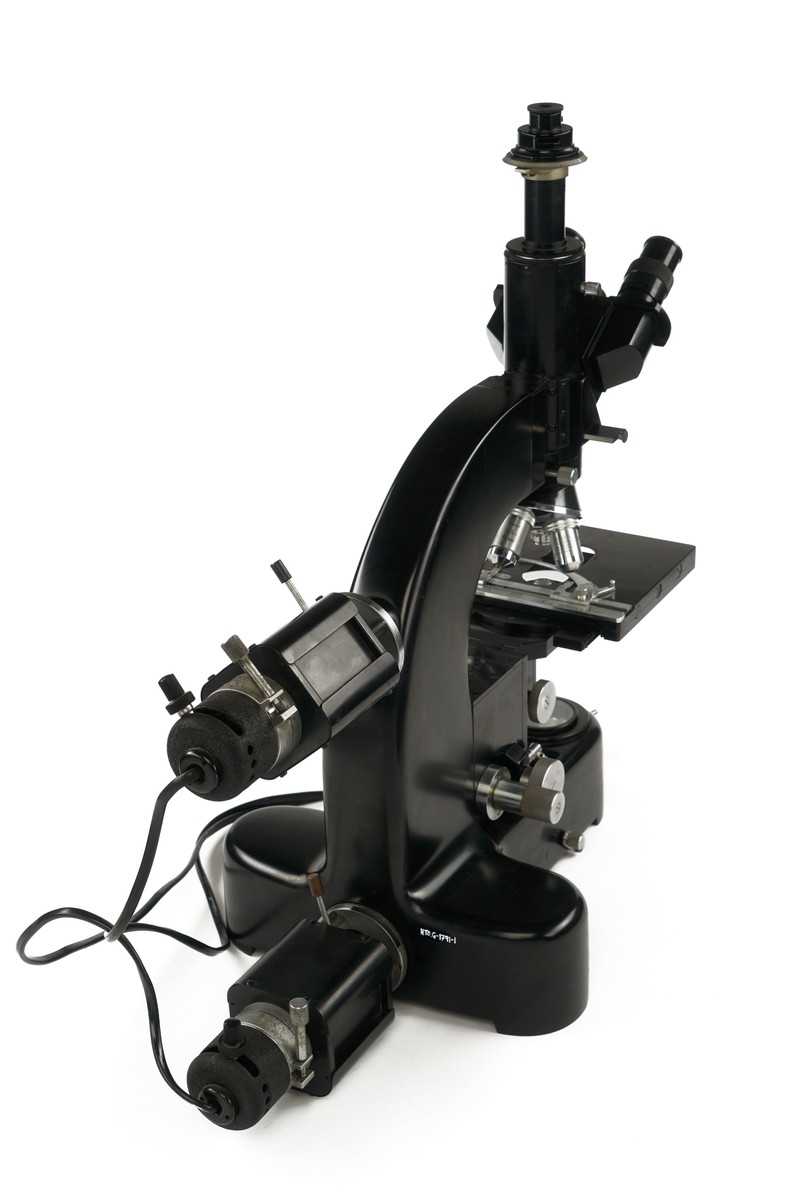 Mikroskop med tre okkularer samt tilkoblet to strøm/lyskilder og medfølgende utstyrskasse i tre som inneholder:
Tre beskyttelseshetter av plast
To okkularer
Tre objektbord
Syv objektfiltere
fire ulike linser
En glassflaske med Immersions olje
En plastpipette for antatt olje
To lyspærer pakket i pappesker
Åtte blendere pakket i pappeske
En nøkkel til kassen pakket i papirpose
En pusseklut