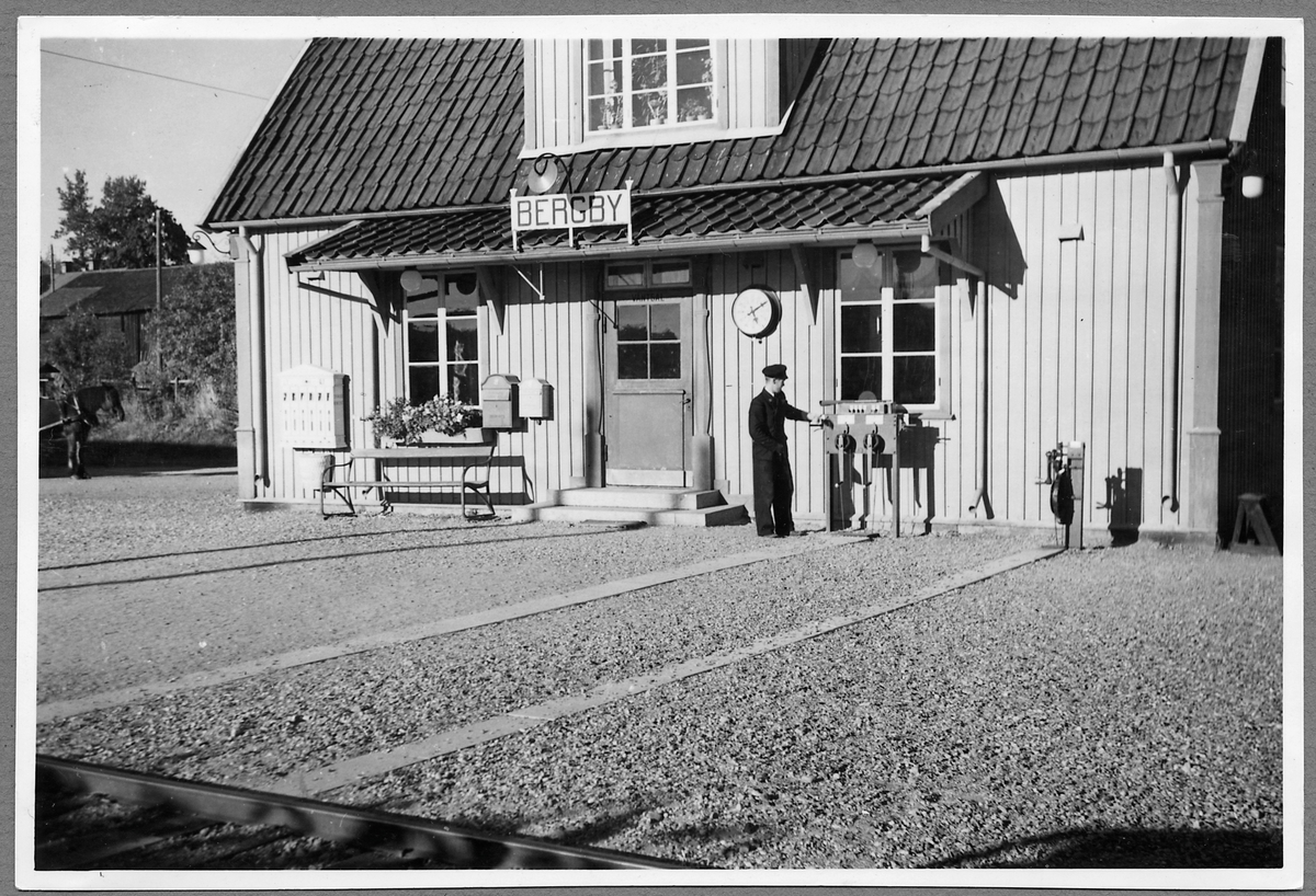 Ostkustbanan, OKB stationshus  i Bergby. Station öppnad 1926 med en- och en halv vånings stationshus i trä. Banan förstatligades 1933. Den elektrifierades 1953. Stationen upphörde 1965.