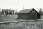 Vy vid Dalaåsbo. Stationhuset byggt omkring 1896/1903  F.d. stationshuset ligger ca 50 meter från banan och är bevarat som privatbostad. Lastplatsens byggnader vid banan helt raserade, enbart betongplattformen återstår. Fundament till bommar vid väg 75 m SO