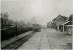 Persontåg och tomt malmtåg på Hälleforsnäs station.
Stationen anlades 1877 och samtidigt uppfördes stationshuset, två våningar i trä. Det moderniserades 1942. Ställverk uppfördes 1916. Mekanisk växelförregling. Bangården har utbyggts dels med nya spår, dels med förlängning av de gamla. Stationen hette NÄS fram till 1.7.1878