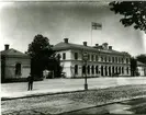 Karlskrona station från gatusidan. Karlskrona - Växjö Järnväg öppnades för allmän trafik 1874. Samma år färdigbyggdes stationshus i två våningar. Bangården utformades så att denna hade plats för fem spår. Moderniseringen av stationen skedde år 1946. Stationen hette Karlskrona Central under perioden 1.9.1954 - 1.9.1957.