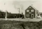 Leksboda stationshus med persontåg vid plattform.