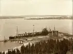 Svartön med elevatorn.
Elevatorn var första malmlastningsanordningen och byggd under åren 1887-1888. Anordningen bestod av en hydraulisk hiss som tog två järnvägsvagnar i taget upp till själva lastbryggan, varifrån malmen tömdes direkt i fartygens lastrum.