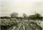 Spår och väg i plankorsning. Redvägsbrunn stationshus.