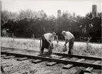 Brandchefen, handelsträdgårdsmästaren Sven Karlsson och brandmannen, trädgårdsmästare Gösta Jakobsson, släcker eldsvådan i spåret  vid Hässelvy villastad station.