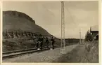 Kaisaniemi. Fyra glada banarbetare utmed spåret vilar på sina spadar. Järnvägen elektrifierades 1915.