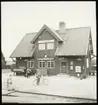 Kvinna med resväska. Man med cykel. Stationsinspektör.