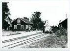 Korsberga station med motorvagn och ånglok på spåren.