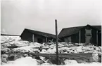 Skaddade byggnader och snö och is rester efter översvämning i Tornedalen.