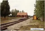 Håll- och lastplats. Envånings stationshus i trä, sammanbyggt i vinkel med godsmagasinet