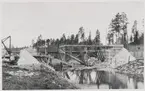 Brobygge över Gruckån strax väster om Vansbro vid uppförandet av Statsbanan Malung-Vansbro 1931-34. Bron över Gruckån ligger på linjen mellan driftplats Vansbro och driftplats Rågsveden.