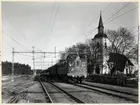 Persontåg draget av ett, Statens Järnvägar, SJ D lok. Vid Huddinge kyrka på sträckan mellan Stuvsta och Huddinge.