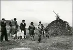 Bussresenärer och samebarn vid en jordkåta på Nordkalotten.