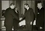 Direktör Erlander Waldenström skakar hand med Erik Upmark, Trafikchef Granfeldt står till höger. från Statens Järnväg, SJ:s 100 årsjubileum 1 december 1956.