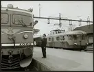 Lokförare i samtal med Herman Thorén vid stationen i Flen maj 1964.
Statens Järnvägar, SJ Rb3 1005 och Trafikaktiebolaget Grängesberg - Oxelösunds Järnvägar, TGOJ motorvagnståg Yoa202 som senare fick beteckningen X21.