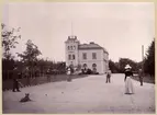 Frövi järnvägsstation 1896. Tennisspel på stationsplan. Den spelande i ljus mössa och ljus rock är stins G. Elgstrand i Frövi. Såsom domare tjänstgör Gustaf Hökerberg stående i gräsmatta (tennisspelets ägare). Fotot är såtillvida unikt, att tennisspelet därå är det första till Sverige från England år 1890 importerade tennisspelet