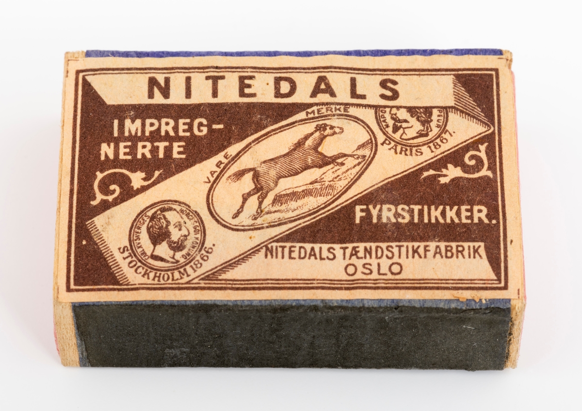 Fyrstikkeske av gammel type. Esken består av to deler, hylster og skuff. Begge deler er laget av tynne treplater som er sammenlimt med tynt papir. Skuffen har et rosafarget papir. Hylstrets dekorpapir har på framsida en etikett, baksiden er ensfarget blå. Den ene sideflata er blå, mens den andre er mer gråblå i fargen. Registrator oppfatter disse sideflatene som ripeflater for å få fyr på fyrstikkene. På etiketten er det avbildet en hest og to medaljer, henholdsvis fra Stockholm i 1866 og Paris i 1867. Esken er fylt opp med 46 ubrukte fyrstikker og 2 fyrstikker uten "hode". Vi har ingen sikker datering for når esken er produsert.
