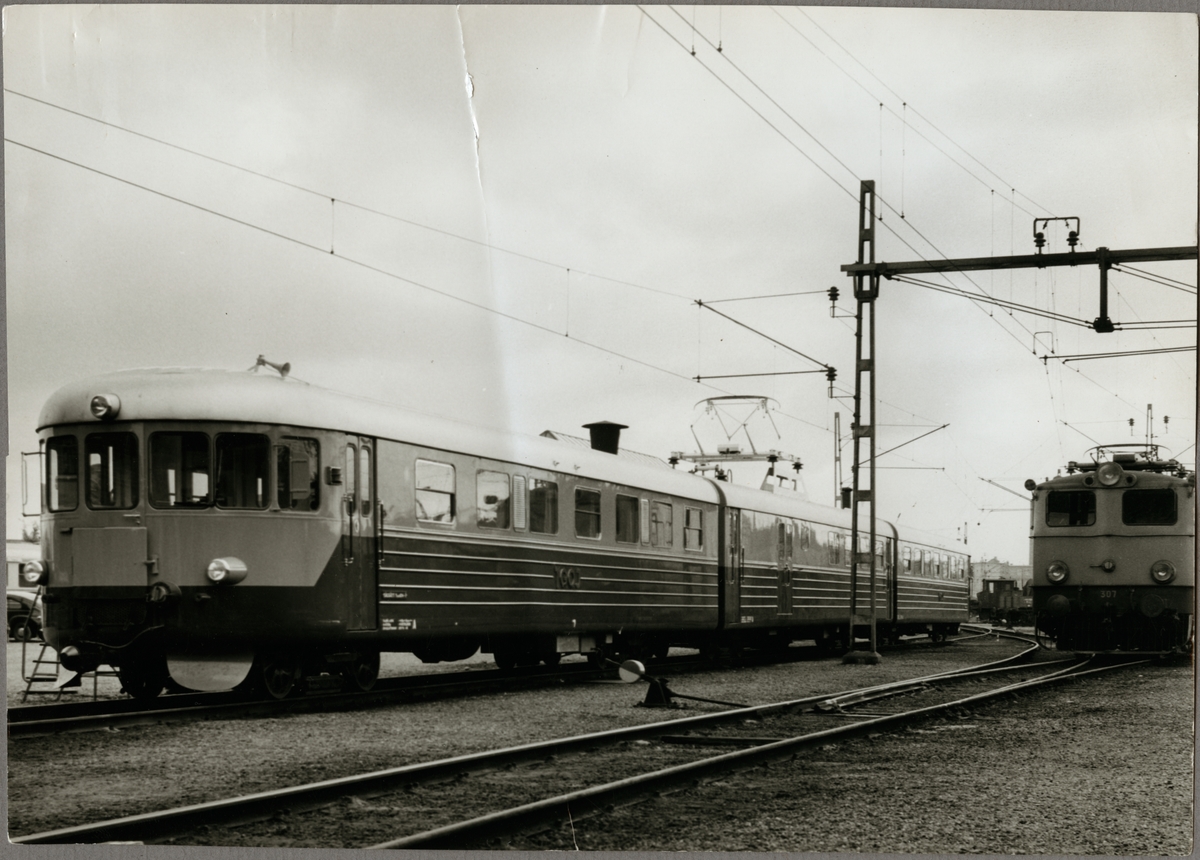 Trafikaktiebolaget Grängesberg - Oxelösunds Järnväg, TGOJ Yoa 104. TGOJ Bt 307 till höger.

Rälsbusståg och ellok på bangård vid växel.