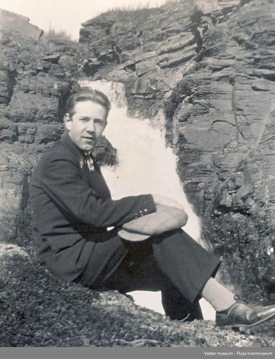 Gottfred Pedersen sitter ved en foss. Ca 1930.