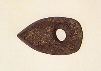 Av grovkornig bergart. Liten och hög. Ovansidan starkt välvd. Nacken slutar tvärt.