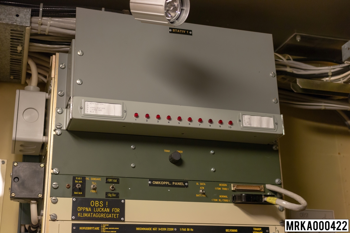 Stativ 1 består av larmenhet, omkopplingspaneler, elcentral 220 V, 24 V, 48 V och kopplingsenhet.
220 V-systemet matas med 3x220 V från ett fristående elverk 16 kVA.
220 V-systemet används för strömförsörjning av eldledningsutrustning, sambandsutrustning, belysning, fläktar, radiatorer, tilluftkanal och klimataggregat.
24 V, 48 V-systemet används för strömförsörjning av övrig sambandsutrustning, nödbelysning och transportvärmare.