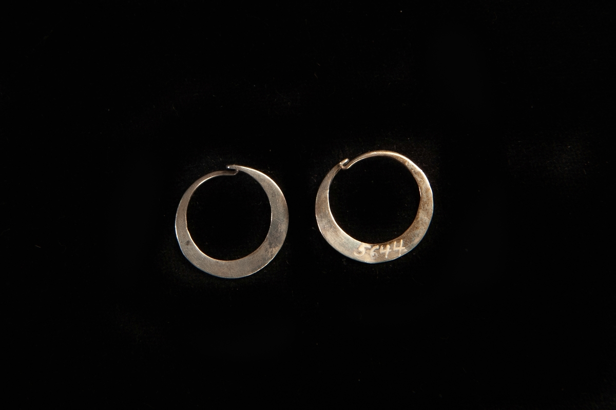 En rund örring av silver. Platt, enkel modell. Hör ihop med JM.5644:1