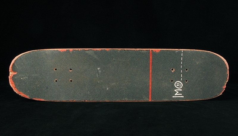 a) skateboardbräda av trä. Hjul saknas. Mått: längd 77,5 cm, bredd 19 cm, tjocklek 1 cm.
b1-b2) svarta skateskor. Märke: DC Shoe.
Märkning: "DCSHOECOUSA".
 Mått: längd 23 cm, bredd 9 cm, höjd 8,5 cm.
c1-c2) vita skateskor.  Märke: DC Shoe. 
Märkning: "DCSHOECOUSA". 
Mått: längd 22 cm, bredd 8, 5 cm, höjd 8,5 cm.