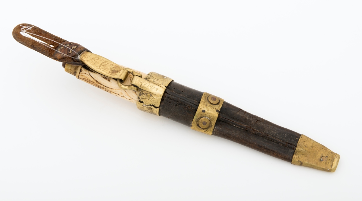 Tollekniv med slire.  Knivens lengde er 20 centimeter.  Den har et gulkvitt beinskaft, som er 10,7 centimeter langt og har et noe konvekst lengdesnitt og et noenlunde ovalt tverrsnitt.  Midten av skaftet måler 2,7 X 2,1 centimeter.  Overflata er prydet med et akantusrelieff.  Langs skaftryggen er det et glatt felt med initialer og årstall: «N P S F[?] 1887».  Det er nærliggende å anta at dette må ha vært en tidligere eiers initialer og anskaffelsesåret.  Beinskaftet har hatt messingholker i begge ender, men bare framholken (nærmest bladet) var intakt da kniven kom til museet.  Den er 1,1 centimeter bred og prydet med linjer langs ytterkantene, ellers glatt.  I overenden av skaftet later det til at ytterspissen på bladtangen er gjenget og påskudd ei kvadratisk mutter med skrådde sideflater.  Bladet er 8,6 centimeter langt og 2,3 centimeter bredt ved brystningen.  Videre framover er imidlertid bladet betraktelig smalere, på grunn av gjentatt sliping.  Den bakre delen av knives nakkeparti er 0,5 centimeter tjukk.

Slira er utført i lær med holker av messing og vedhengslet stropp for knappefeste i bukselinninga.  Samlet lengde er 27,8 centimeter.  Sjølve slira er 16 centimeter lang, fra enden av doppskoen til overkanten av munningsholken (målt på framsida, ikke hengslingspunktet bak).  Slirelæret er mørkebrunt og sammensydd med en søm som er plassert på «baksida», altså den sida som skulle vende inn mot bærerens kropp.  Framsida av doppskoen er merket med årstallet «1851», altså en datering som overgår den vi finner på knivskaftet med 36 år.  På baksida av doppskoen er det inngravert et symmetrisk akantusmønster med C-ornamenter.  Doppskoen er naglet fast i slirelæret ved hjelp av ei gjennombrutt nagle.  Akantusmønsteret fra doppskoens bakside finne vi igjen også på midtholken, som er drøyt 1,8 centimeter bred.  Ettersom holkene ikke er forbundet ved hjelp av sideskinner er også midtholken forankret i læret ved hjelp av nagler på sliras bakside.  Overholken eller munningsholken er 1,9 centimeter bred, og har samme akantusmønster som midtholken og baksida av doppskoen.  Også her er det naglefester i slirelæret.  Munningsholken har en sprekkskade, egentlig et brudd, på det som framstår som baksida av slira.  Her finner vi også et hengslingspunkt med ei U-formet bøyle som danner overgang til ei 4,5 centimeter lang og 1,5 centimeter bred messingspenne.  På forsida av denne spenna er det akantusdekor, på baksida finner vi initialene «B C L».  Spenna må ha vært beregnet på feste av knivslira i linninga på bærerens bukse.  Da kniven ble overlatt til museet var den imidlertid utstyrt med ei lærhempe med en splitt som kunne tjene som festepunkt på en knapp.