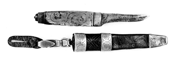 Tollekniv med slire.  Knivens lengde er 20 centimeter.  Den har et gulkvitt beinskaft, som er 10,7 centimeter langt og har et noe konvekst lengdesnitt og et noenlunde ovalt tverrsnitt.  Midten av skaftet måler 2,7 X 2,1 centimeter.  Overflata er prydet med et akantusrelieff.  Langs skaftryggen er det et glatt felt med initialer og årstall: «N P S F[?] 1887».  Det er nærliggende å anta at dette må ha vært en tidligere eiers initialer og anskaffelsesåret.  Beinskaftet har hatt messingholker i begge ender, men bare framholken (nærmest bladet) var intakt da kniven kom til museet.  Den er 1,1 centimeter bred og prydet med linjer langs ytterkantene, ellers glatt.  I overenden av skaftet later det til at ytterspissen på bladtangen er gjenget og påskudd ei kvadratisk mutter med skrådde sideflater.  Bladet er 8,6 centimeter langt og 2,3 centimeter bredt ved brystningen.  Videre framover er imidlertid bladet betraktelig smalere, på grunn av gjentatt sliping.  Den bakre delen av knives nakkeparti er 0,5 centimeter tjukk.

Slira er utført i lær med holker av messing og vedhengslet stropp for knappefeste i bukselinninga.  Samlet lengde er 27,8 centimeter.  Sjølve slira er 16 centimeter lang, fra enden av doppskoen til overkanten av munningsholken (målt på framsida, ikke hengslingspunktet bak).  Slirelæret er mørkebrunt og sammensydd med en søm som er plassert på «baksida», altså den sida som skulle vende inn mot bærerens kropp.  Framsida av doppskoen er merket med årstallet «1851», altså en datering som overgår den vi finner på knivskaftet med 36 år.  På baksida av doppskoen er det inngravert et symmetrisk akantusmønster med C-ornamenter.  Doppskoen er naglet fast i slirelæret ved hjelp av ei gjennombrutt nagle.  Akantusmønsteret fra doppskoens bakside finne vi igjen også på midtholken, som er drøyt 1,8 centimeter bred.  Ettersom holkene ikke er forbundet ved hjelp av sideskinner er også midtholken forankret i læret ved hjelp av nagler på sliras bakside.  Overholken eller munningsholken er 1,9 centimeter bred, og har samme akantusmønster som midtholken og baksida av doppskoen.  Også her er det naglefester i slirelæret.  Munningsholken har en sprekkskade, egentlig et brudd, på det som framstår som baksida av slira.  Her finner vi også et hengslingspunkt med ei U-formet bøyle som danner overgang til ei 4,5 centimeter lang og 1,5 centimeter bred messingspenne.  På forsida av denne spenna er det akantusdekor, på baksida finner vi initialene «B C L».  Spenna må ha vært beregnet på feste av knivslira i linninga på bærerens bukse.  Da kniven ble overlatt til museet var den imidlertid utstyrt med ei lærhempe med en splitt som kunne tjene som festepunkt på en knapp.