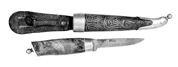 Kniven har lysebrunt skaft av bjørkerot eller rikule. Messingholk nederst på skaftet og beinplate øverst. Slira er av bukkehorn med messingholker. Bladet er antakelig smidd av Herbjørn Sveinsen Runnekås i Tinn Austbygd, mens det øvrige knivmakerarbeidet skal være utført av Olavius Nilsen Hatlelid, som bodde i Volda.