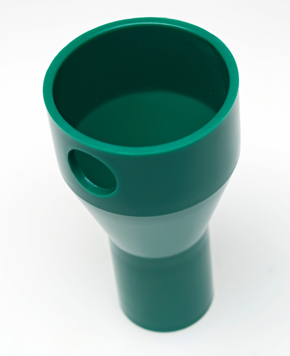 Koblingsstykket er brukt for å feste støvsugerens sugeslange til renseren. 

Bærrenseren består av fire deler, og er laget av grønn og hard plastikk. Renseren består av et rør, en trakt og to koblingsstykker. 

Gjenstanden er innkjøpt til Norsk Skogmuseum, og har aldri vært i bruk. 