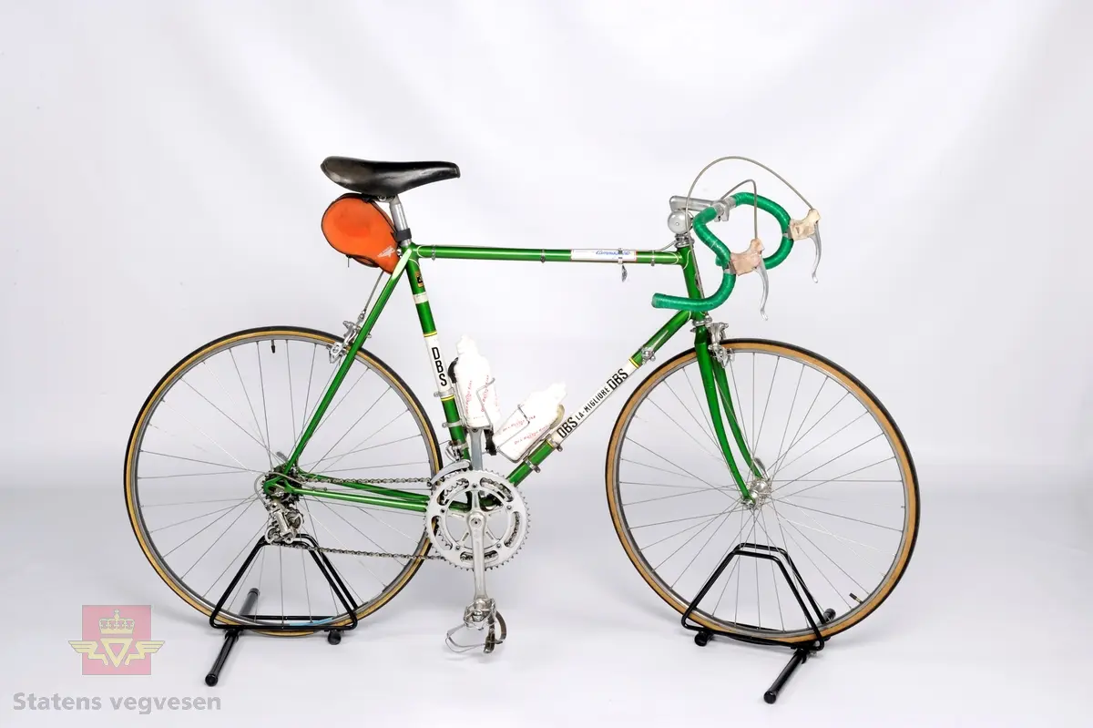 Størrelse: 57 cm. Dekk: Clement pariserdekk (622 mm). Nav foran: Campagnolo Record. Nav bak: Campagnolo Record gjenget for frikrans. Brems: Campagnolo felgbremser foran og bak. Gir: Campagnolo Record 2 x 7. Hovedfarge er grønn. Bakhjulet er uoriginalt.