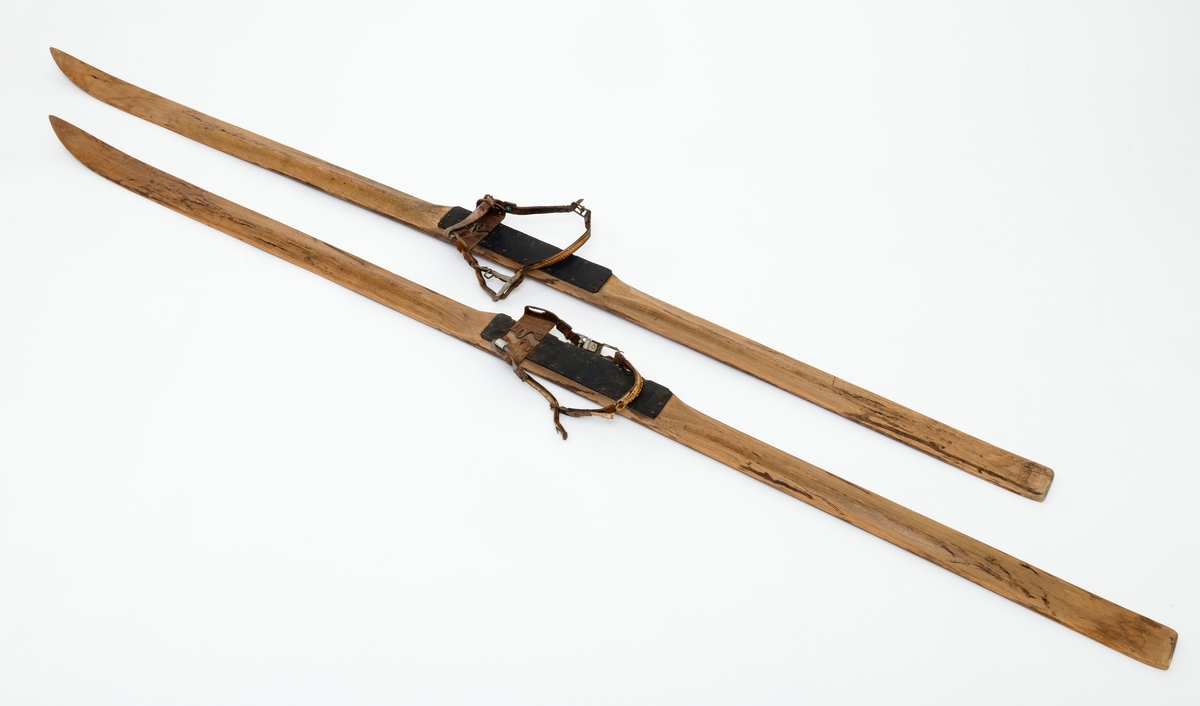 Skiene er brukt av Erik Andersson, Moelv, for å komme fram til fiskeplasser på Mjøsa. Skiene har bindingen av typen "Gresshoppa" no. 1, og er en tåbinding med bakbinding. Skiene er heltreski av hickory. De er 213 - 213,5 centimeter lange, målt i rett linje mellom bakender og tupper. Bredden foran, der hvor krumminga mot tuppene begynner er 7,3 - 7,4 centimeter. På midten, ved «fotstegene», der støvlene til skiløperen skulle festes, er bredden 6,1 centimeter, og i bakendene er breddemålet 6,5 centimeter. Sistenevnte mål er tatt cirka 4 centimeter framfor endene, som her er noe innsvingte. Tjukkelsen der hvor krumminga mot tuppene starter er 7-8 millimeter. Ved fotstegene er skiene om lag 3,0 centimeter tjukke, og i bakendene 1,4 centimeter. Langs midtaksene på sålene er det høvlet 1,5 centimeter brede styrerender. Oversidene av skiene er planhøvlete fremst, mot tuppene, og på fotstegene. Mot fotstegene har overflatene markerte, avrundete midtrygger. Skiene har bindinger med tåjern, bestående av to vinkeljern som er fastskrudd med en innbyrdes avstand og innbyrdes vinkler som skulle passe til den fremre delen av støvlesåla til skiløperen. På yttersidene av de oppovervendte delene av tåjerna er det montert hengsler for reimene som har fungert som bakbindinger. Dette er L'labbé Lunds patentbindinger fra 1920-åra. Fotstegene - både like foran og like bak tåjerna - er beslått med biter av svart gummi, som skulle forebygge slitasje fra støvlesålene.

Skiene er blitt brukt av givers bestefar. Han var en ivrig isfisker.  Skiene ble gjerne brukt som fremkomstmiddel til pilkeplassene. Familien hadde faste plasser og faste pilkehull som ingen andre fikk bruke, og det ble fisket mye ved Thomasøra. Den gjeveste fisken å få var ørret, men de pilket også etter sik. De fisket bare 15-30 cm. under isen. Denne siken gikk under navnet oppundersik. De fikk også mye abbor som de ga bort til naboer som de visste likte fisk. 

De pilket lake ved Helgeberget rundt påsketider, og klubbet lake på isen på grunt vann. For å komme fram til pilkeplassene ble det brukt skøyter, ski eller spark.