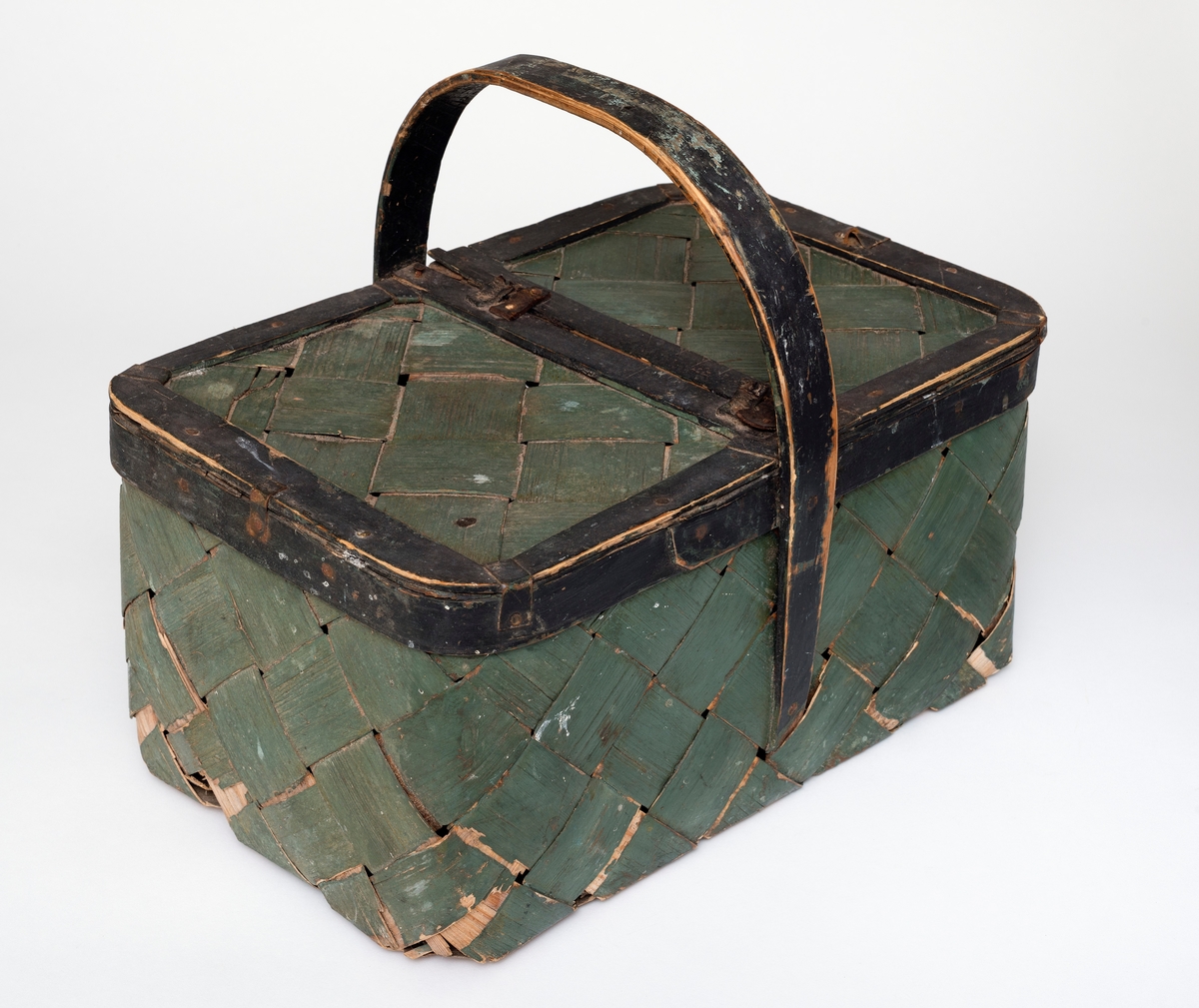 Sponkurven har en rektangulær form, og den har et lokk som er delt i to, hvorav den ene delen kan åpnes. Lokket er hengslet sammen med fire lærbiter.  Lokket festes med en metallhempe. 

Kurven er i skråflettet spon, og det er sprikret på en kant/avslutning på kurven. Kurven har også en hank som er tilspikket. Den har en umalt innside, yttersiden er malt grønn, og kanten og hanken er malt svart. 