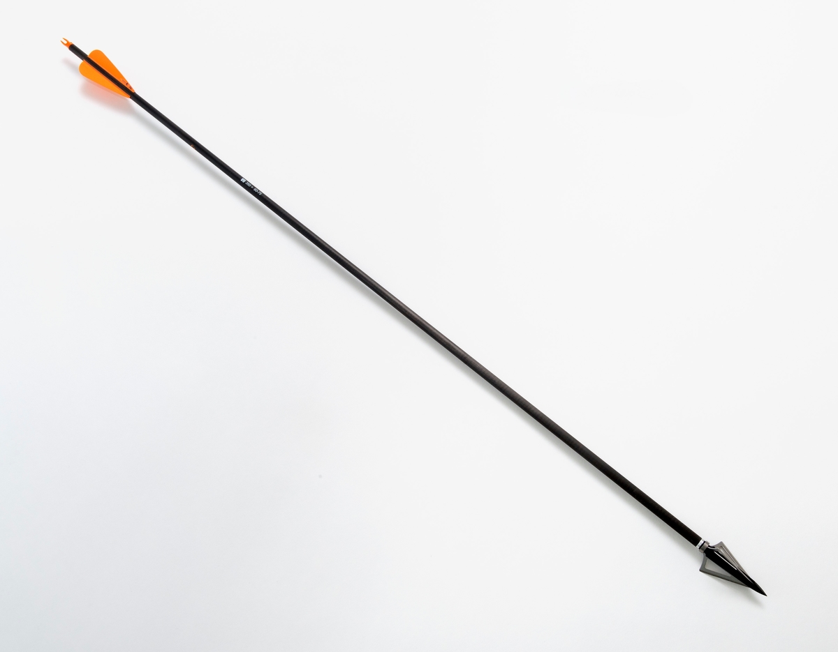 Pil av karbonmateriale (karbonfiber) utstyrt med jaktpil (spiss) med tre skjær. Skjærene er av stål. Pilen har styrefjær av kunststoff i oransje og hvitt. Pilen har en oransje nock av plastmateriale i enden som tres på buestrengen. 
Pilen og har gjenger i ene enden, slik at spissen kan byttes etter behov. 