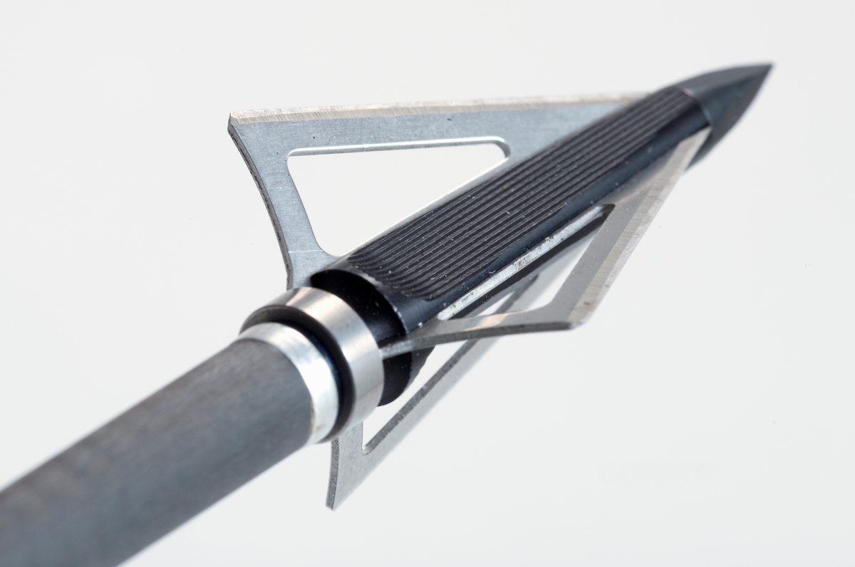 Pil av karbonmateriale (karbonfiber) utstyrt med jaktpil (spiss) med tre skjær. Skjærene er av stål. Pilen har styrefjær av kunststoff i oransje og hvitt. Pilen har en oransje nock av plastmateriale i enden som tres på buestrengen. 
Pilen og har gjenger i ene enden, slik at spissen kan byttes etter behov. 