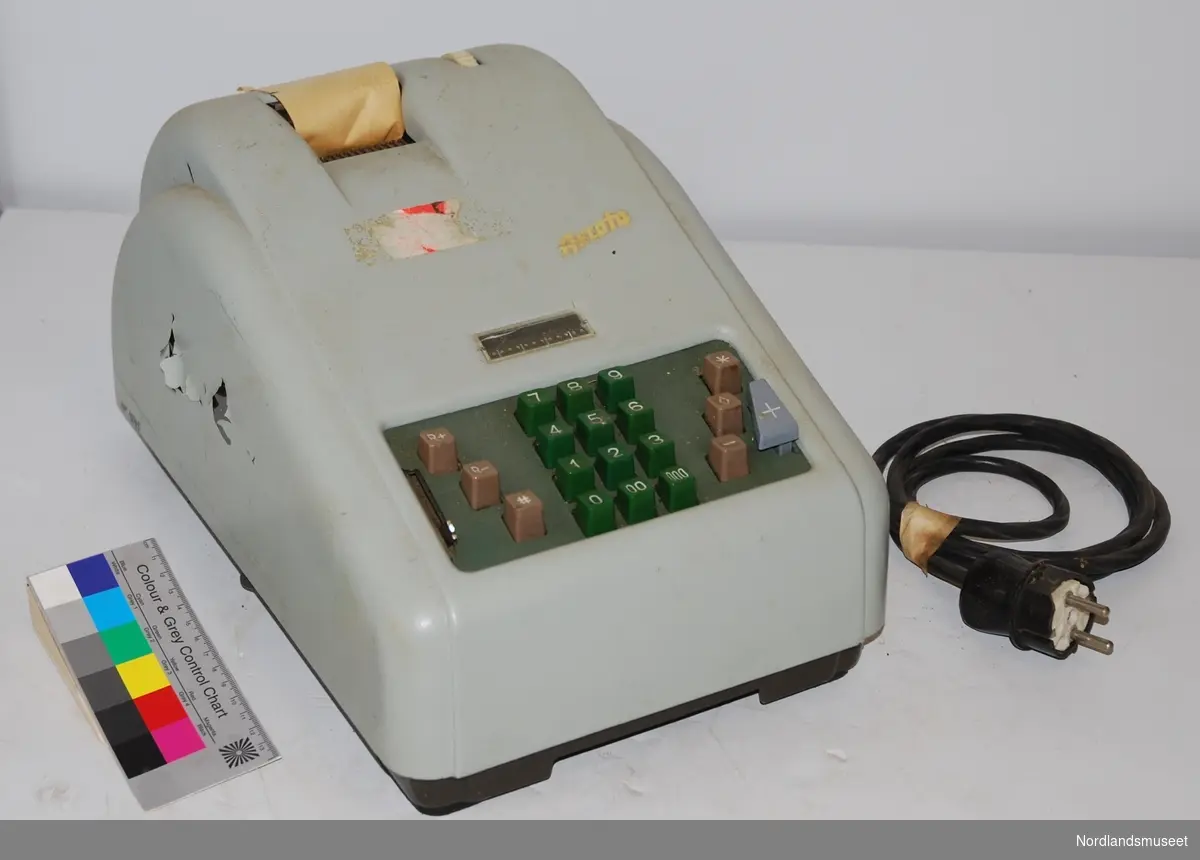 electric grey calculating machine with green and grey buttons, paper roll still attached