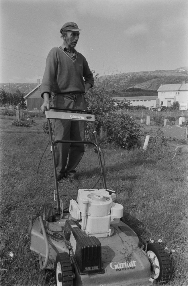 Leirfjord, Leland. Kirkegårdsarbeider, Sigurd Johnsen, klipper plenen på kirkegården.
Bildet fra Helgeland Arbeiderblad sin sommerpatrulje.
Finnes også som VBH.F.2011-010-0079