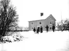 Norrgården i Ormesta, tvåvånings bostadshus, 5 personer i snön framför huset.
August Perssons bostad.
Karl Persson.