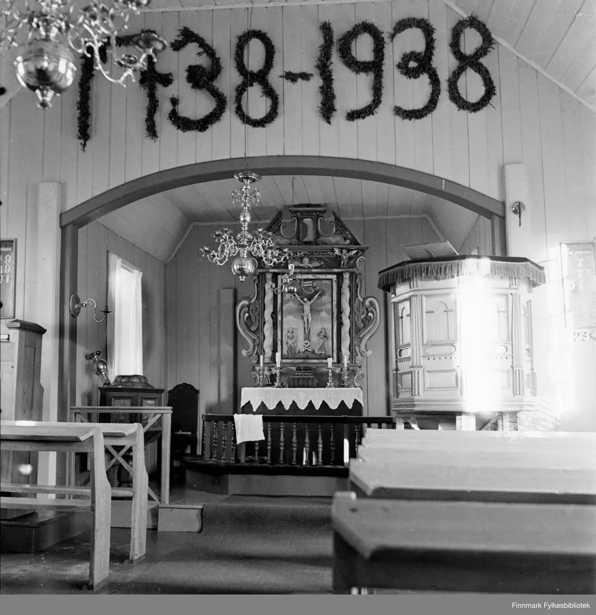 Kjøllefjord kirke 1940. Altertavle fra 1600-tallet.  Årstallene utformet av bjørkeløv markerer at kirken feiret 100 års jubileum et par år før bildet er tatt. En historie sier at altertavla ble gitt til Skjøtningberg kirke av en takknemlig tysk skipper som ble reddet fra forlis utenfor Skjøtningberg. Altertavlen og flere andre gjenstander ble siden flyttet til gamle Kjøllefjord Kirke. I bildet ser man også en stor gotisk bibel. Denne bibelen ble reddet fra tyskernes nedbrenning av Kjøllefjord i 1944 da Hildur Hustad tok den med og flyktet til fjells. Ved den tyske tilbaketrekkingen fra Finnmark praktiserte de Den brente jords taktikk og tente på store deler av all bebyggelse i Finnmark. Kjøllefjord kirke var landets eldste kirke. Bibelen oppbevares fortsatt i Kjøllefjord, i et brannsikkert hvelv. Johan og Hildur Hustad fra Kristiansund, kom til Kjøllefjord i 1912. De holdt til på Sveenbruket på vestsiden i to år inntil bruket i Kluben ble ferdig. Der var det kai, egnebu, pakkhus med salteri i underetasjen og bolig og kontor i 2.etasje. Ditto ett pakkhus med blant annet trandamperi og boligrom. Pakkhus nr. 3 ble bygd i trettiårene. Hjellbruk langs fjæra og oppe i fjellsida. Hustad solgte solar, parafin og smøreolje for Vestlandske Petroleumscompani. G. Robertsen styrte over både Hustad- og Sveenbruket. Senere ble også firmanavnet endret til G. Robertsen. I 1940 flyttet Hustad fra Klubben og overtok Sveenbruket. Johan Hustad døde i 1942. 

Interiør Kjøllefjord gamle kirke med altertavle fra 1600-tallet. Kjøllefjord kirke var bygd i 1738 og sto i Kjøllefjord frem til den ble påtent av tyske soldater 4.november 1944. Kirken lå i Kjøllefjord prestegjeld som ble opprettet i 1685, da Skjøtningberg prestegjeld ble nedlat. Mye av inventaret stammet fra Skjøtningberg krike. Sakrestiet hadde en altertavle med årstallet 1662 som viser nattverdens innstiftelse. Denne skal tidligere å stått i Omgang kirke. Den opprinnelige kirken skal være byd mellom 1668 og 1683 og var en liten kirke bygget av rundtømmer. I kirken fantes også to klokker, hvorav den ene hadde inskripsjonen «Eine gude klock hin ick genant, den hört meinen klanck tho bargen int landt des late ick mi nicht vordreten. Heinrich Meier tho Bremen de oldermand he heft mi laten geten 1608. Restene av kirkeklokken kan ses i den nye Kjøllefjord kirke. Også den gotiske bibelen ble reddet av Hildur Hustad som tok med bibelen da hun flyktet til fjells. Bibelen oppbevares i dag i en bankboks i Kjøllefjord.