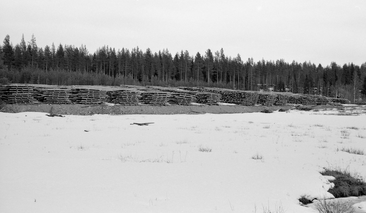 Tømmertillegging ved fløtingsvassdrag i Glommadalføret. Fotografiet skal være tatt våren 1961 ved Gammelbudammen i Julussvassdraget.  Vi ser hvordan fløtingsinspektørene ville at tømmeret skulle ligge i påvente av at fløtingssesongen kunne starte, nemlig i «strøvelter». Tømmeret lå på elvebrinken, i floer, parallelt med strømretningen og med mellomliggende strøstokker, som bidrog til at tømmeret fikk luft og litt tørk før det ble slått på elva. Denne forsiktige tørken reduserte faren for at stokkene ble for vasstrukne og sank under fløtinga.