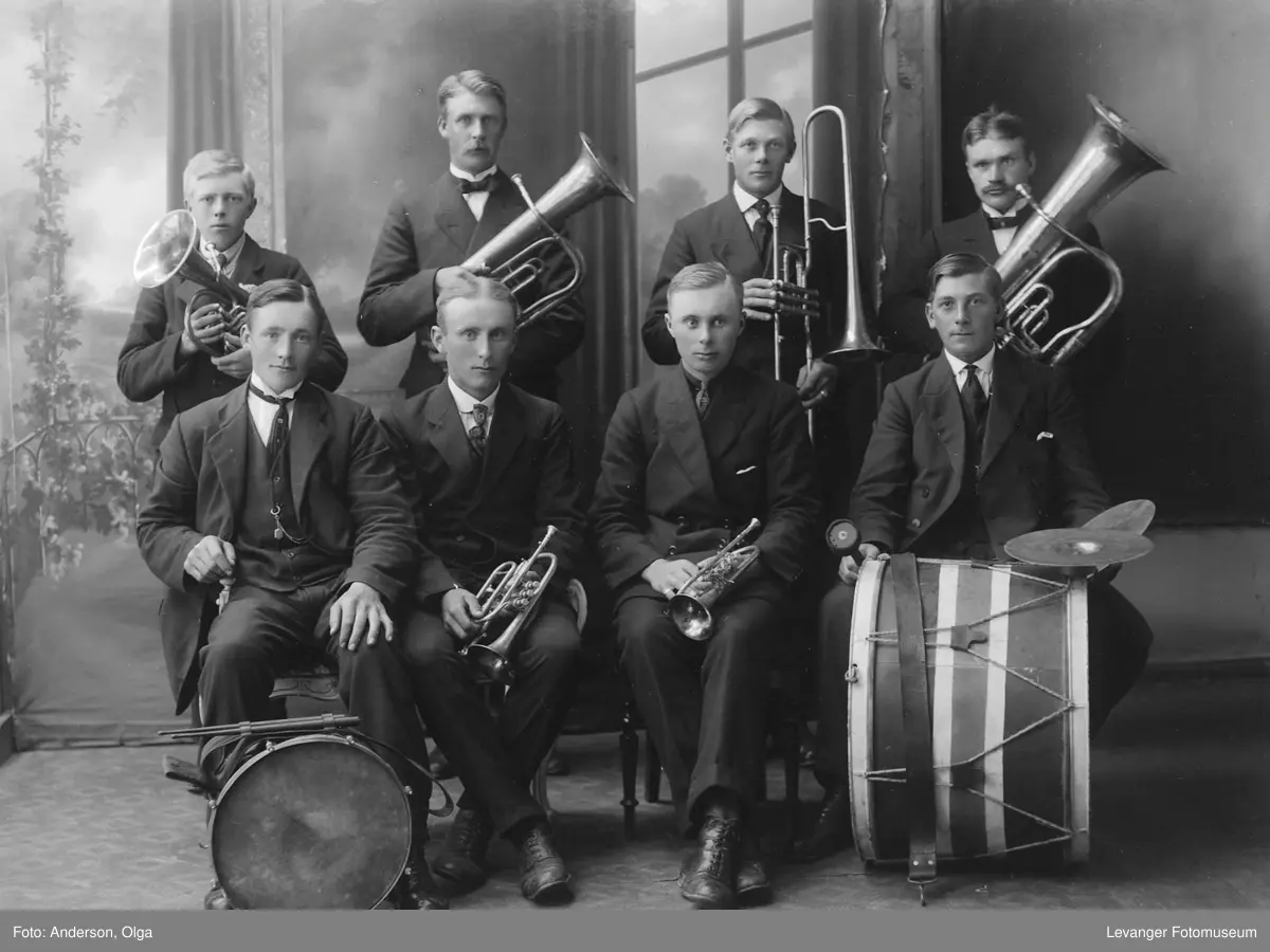 Gruppebilde av musikklag/orkester med blåsere og trommer