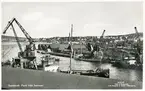 Vy över Järnvägsbassängen och massamagasinen vid Rosenborg. Kolhögar och lastande fartyg vid kajerna. Vykort.