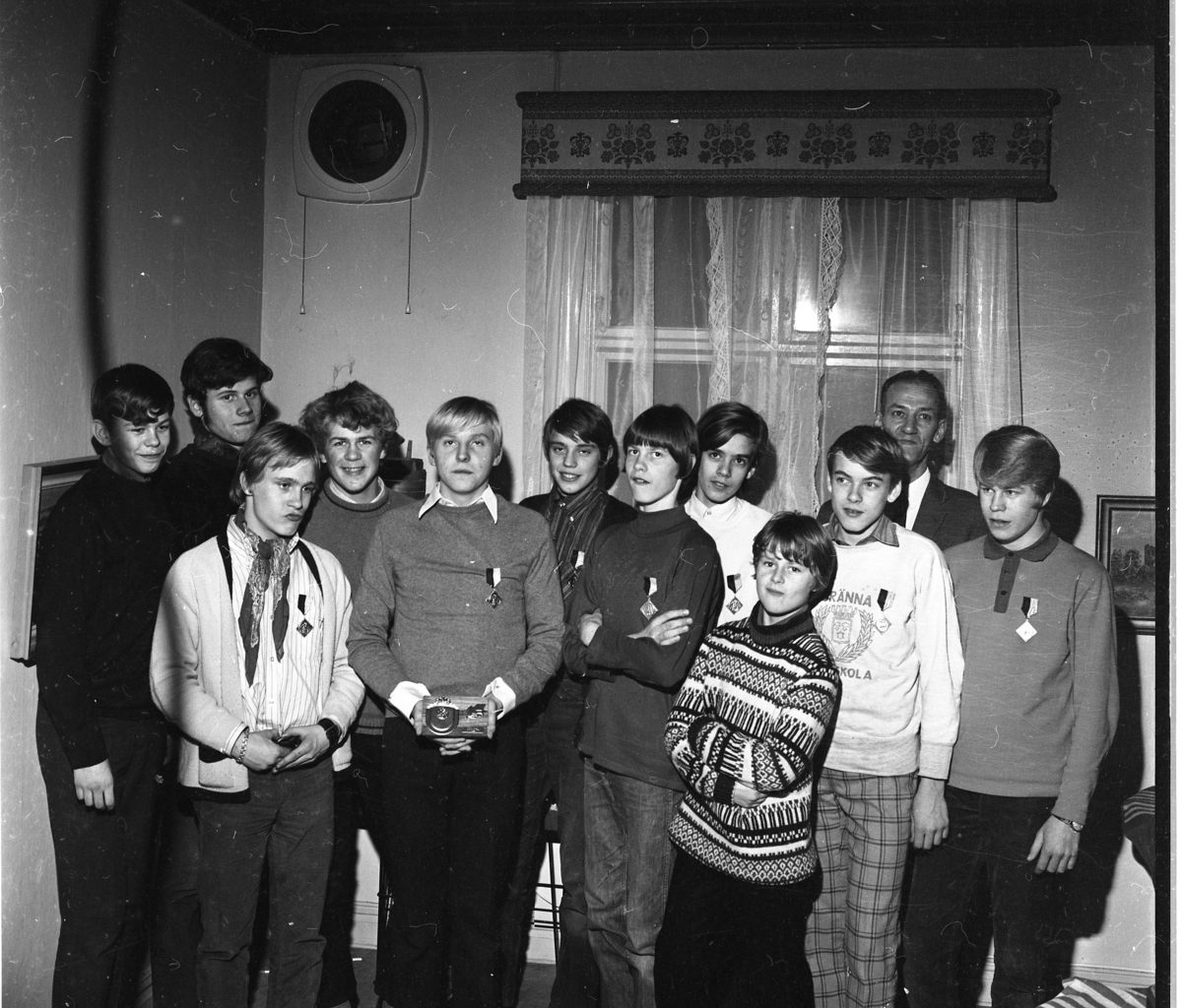 Gränna AIS pojklag i bandy, 1968. Pojkar i ett rum, stående med utmärkelser på bröstet. Från vänster: Ove Englund, Lars Svärd, okänd, Håkan Nyqvist, okänd, Hans Karlsson, Lars-Göran Blom, okänd, okänd, Bertil Fong, ledaren Thure Karlsson samt Tomas Johansson.